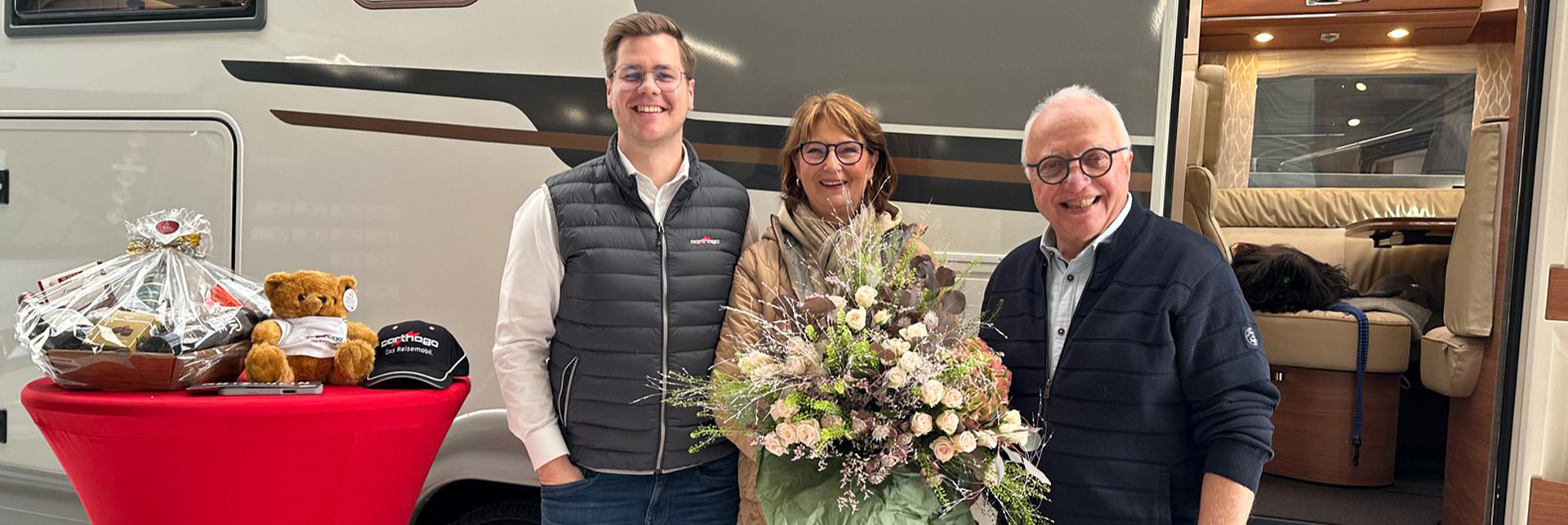 Gruppenbild dreier Personen mit Carthago Wohnmobil im Hintergrund